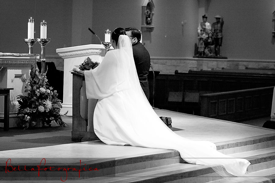 black and white of bridal couple kneeling at the altar