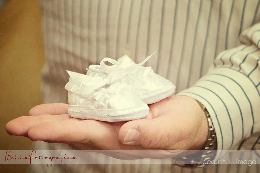 daddy holding baby shoes