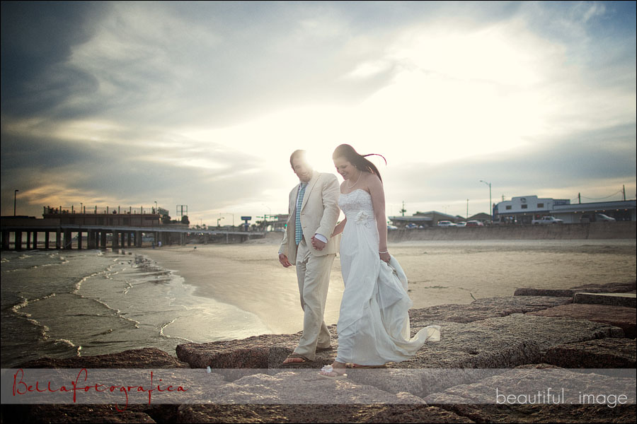 bride and groom on jetty at the beach