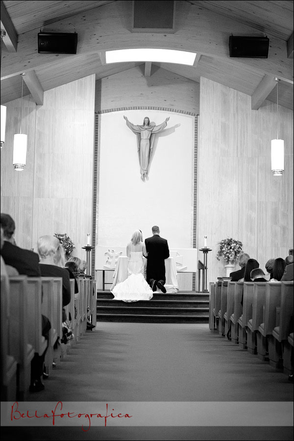 groom and bride kneeling at altar