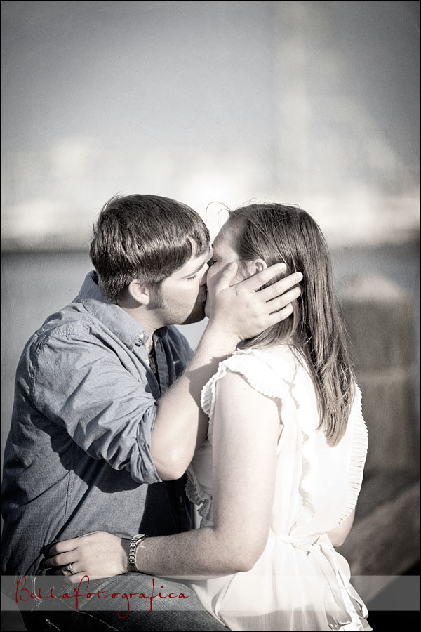engaged couple kissing on boardwalk
