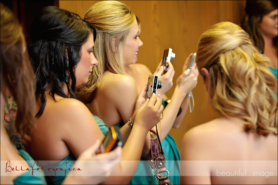bridesmaids looking on and photographing
