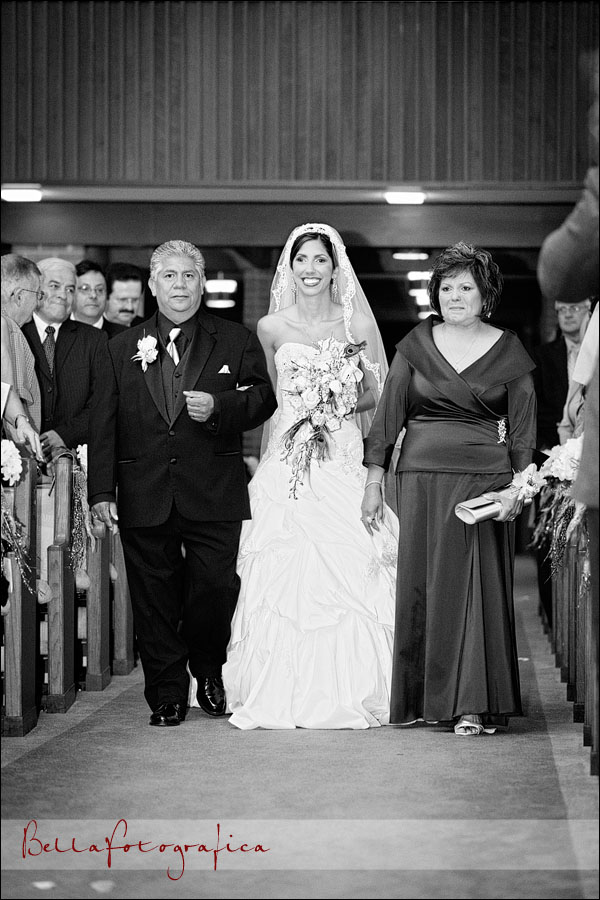 bride walking with her parents up the aisle