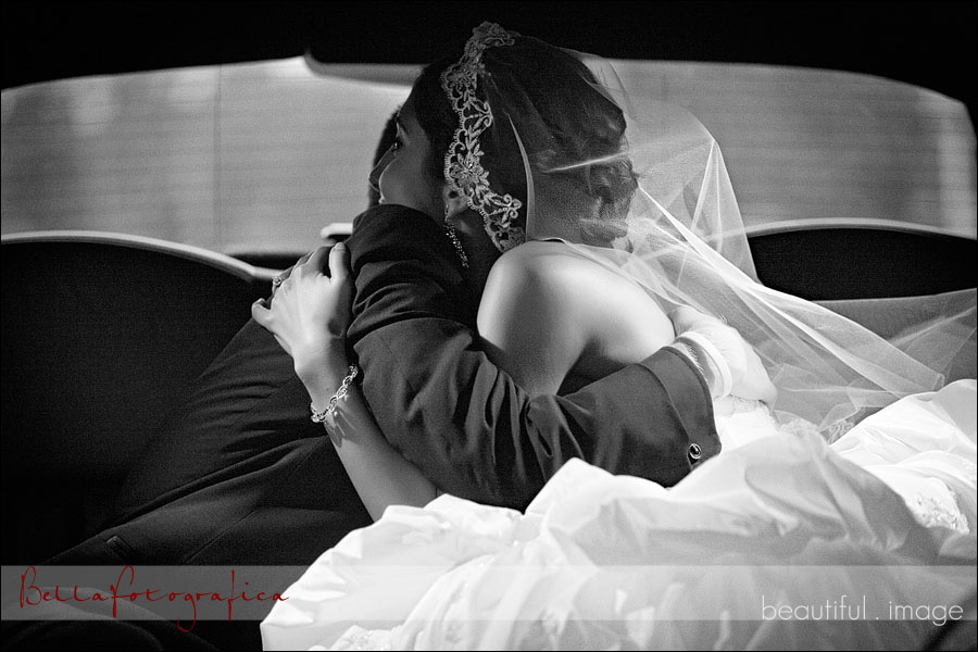 bride and groom hugging in limo