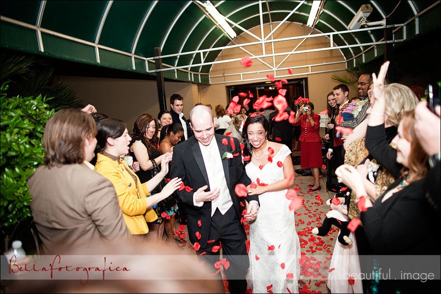 bride and groom leaving under rose petals