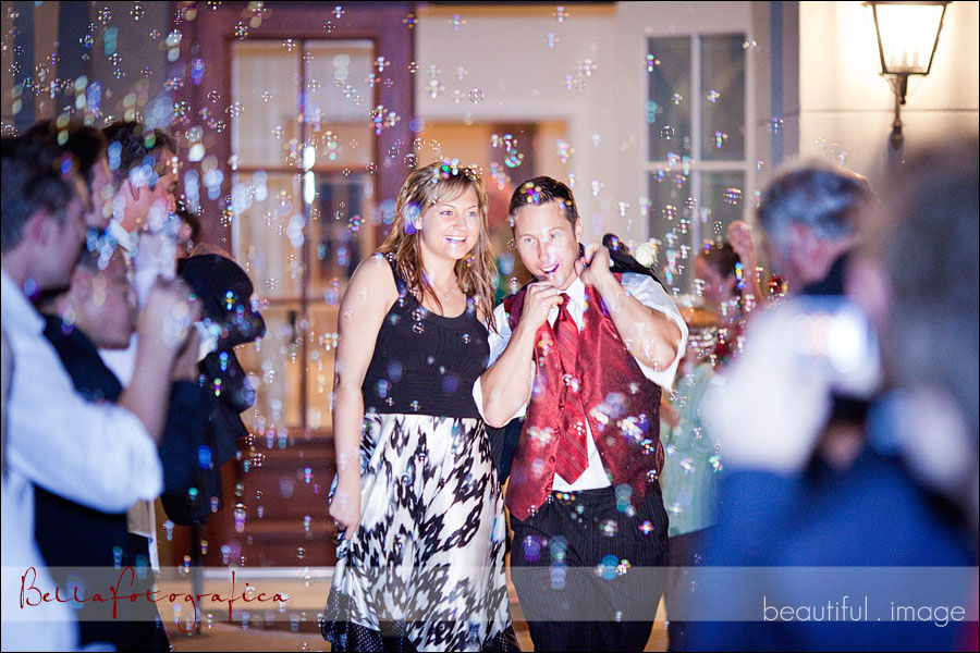 bride and groom leaving for honeymoon through bubbles