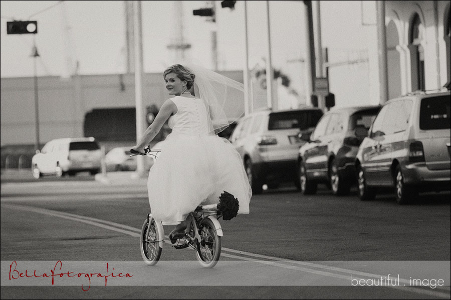 bride riding a bike on the strand