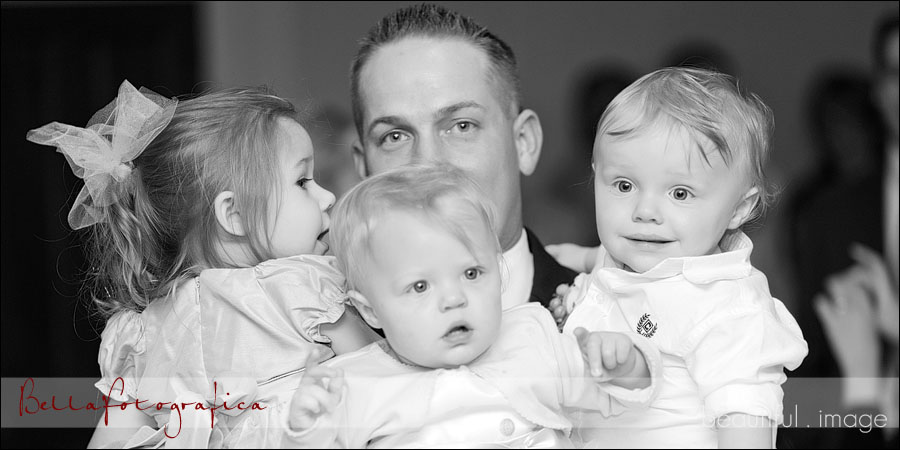 groom holding three toddlers