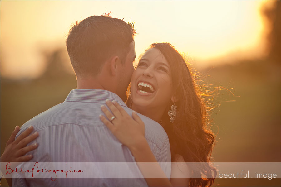 engaged couple with sun setting behind them