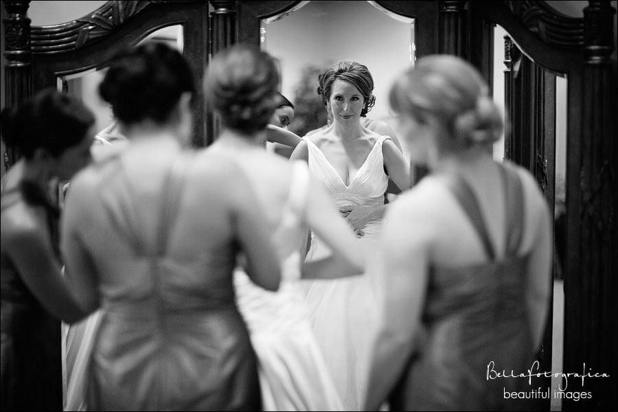 bride stepping into dress in mirror